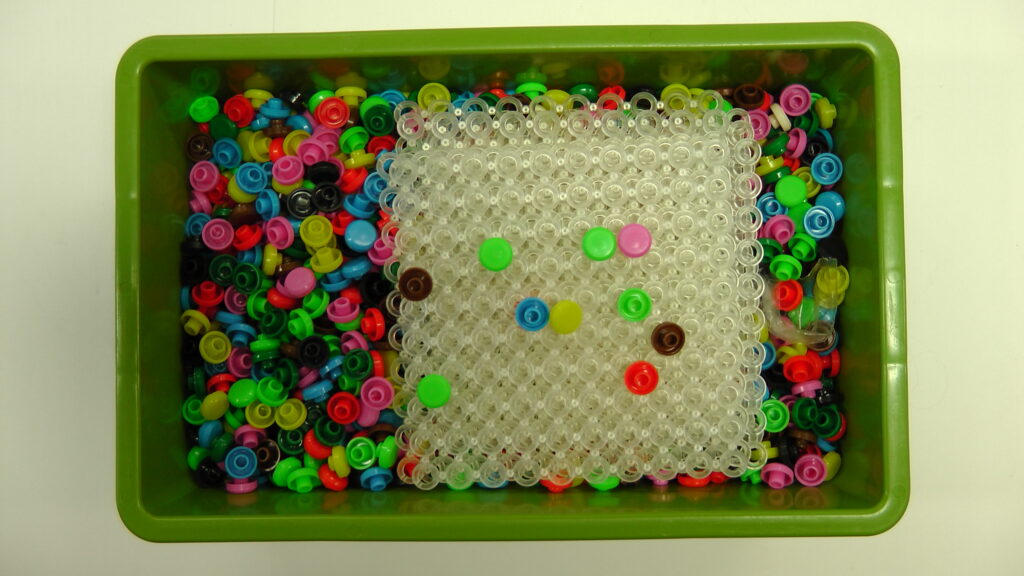 Jetons Matrica (pions-pressions) de différentes couleurs avec des grilles en plastique souple transparent